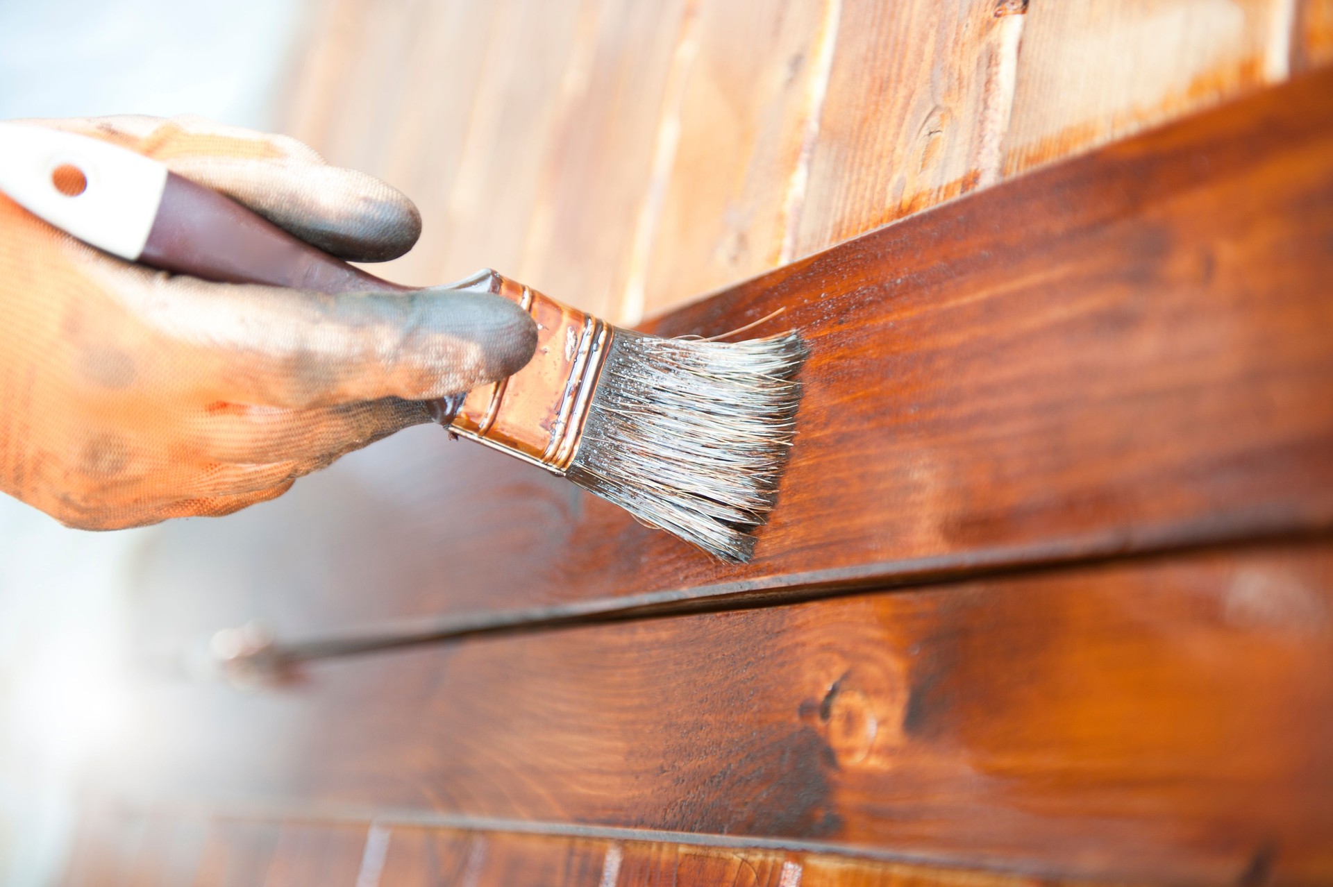 Male Carpenter Applying Varnish To Wooden Furniture